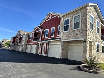 a row of brick houses with white garage doors  at Watermark at Steele Crossing, Fayetteville